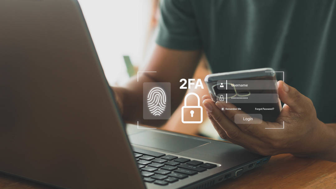 Kaksivaiheinen tunnistautuminen verkkosivustolle kannettavan tietokoneen ja älypuhelimen avulla. Käyttäjä syöttää kirjautumistietojaan ja käyttää sormenjälkitunnistusta.